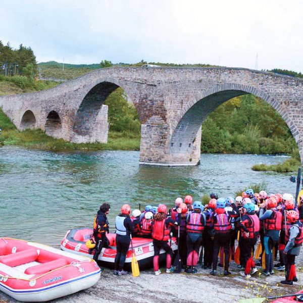 Gente a orillas del río Irati en Aoiz preparando la balsa para una actividad de rafting familiar cerca de Pamplona